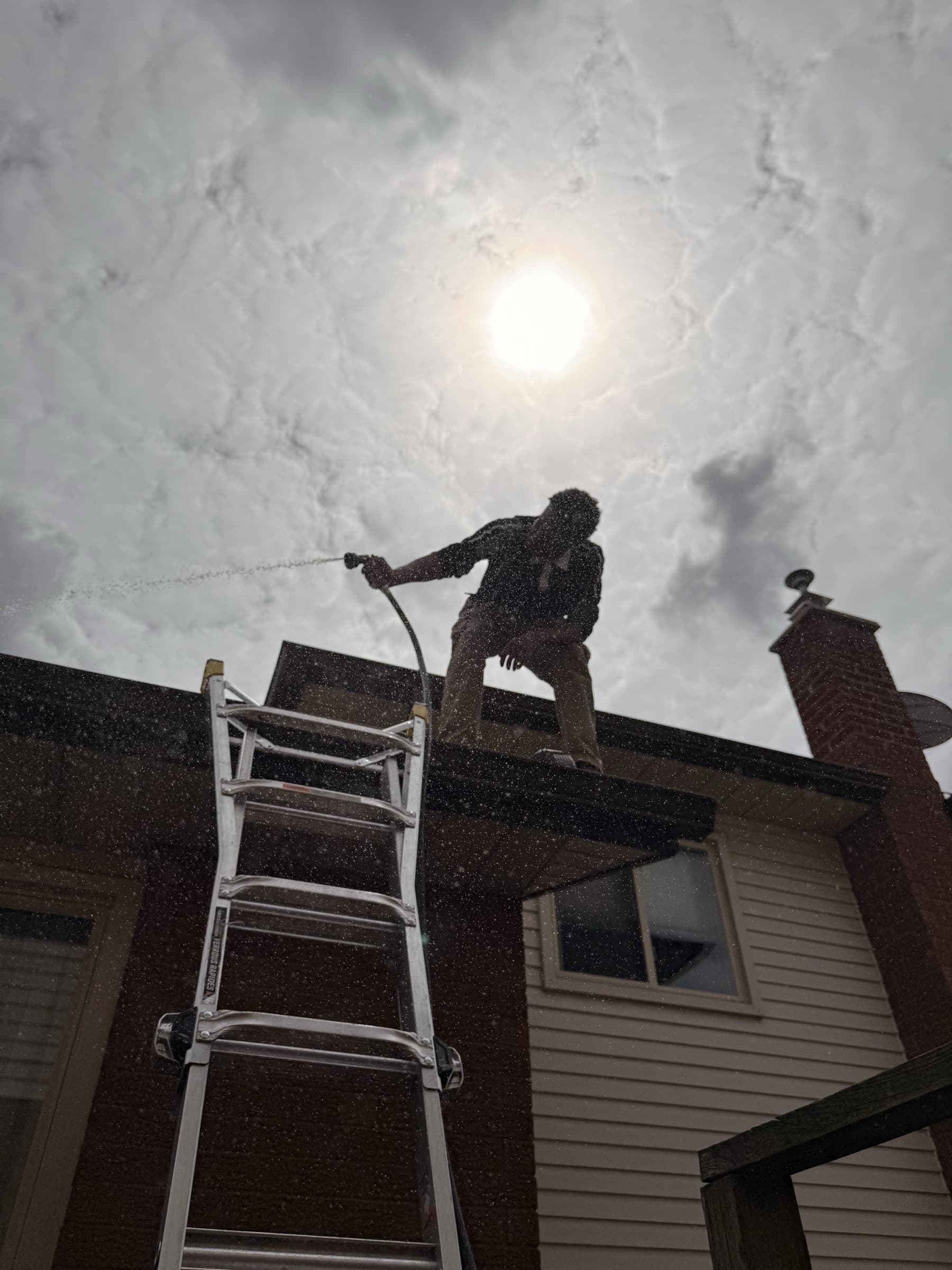 Lume Windows technician on a rooftop cleaning upper-level windows